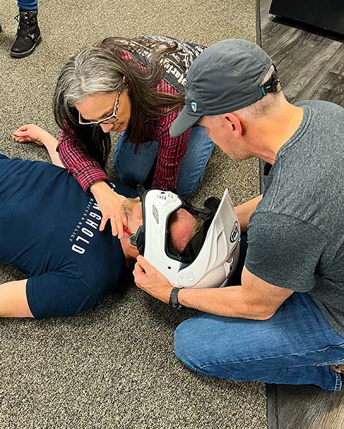 Motorcyclists practicing how to remove a helmet after an accident if a rider cannot breathe.